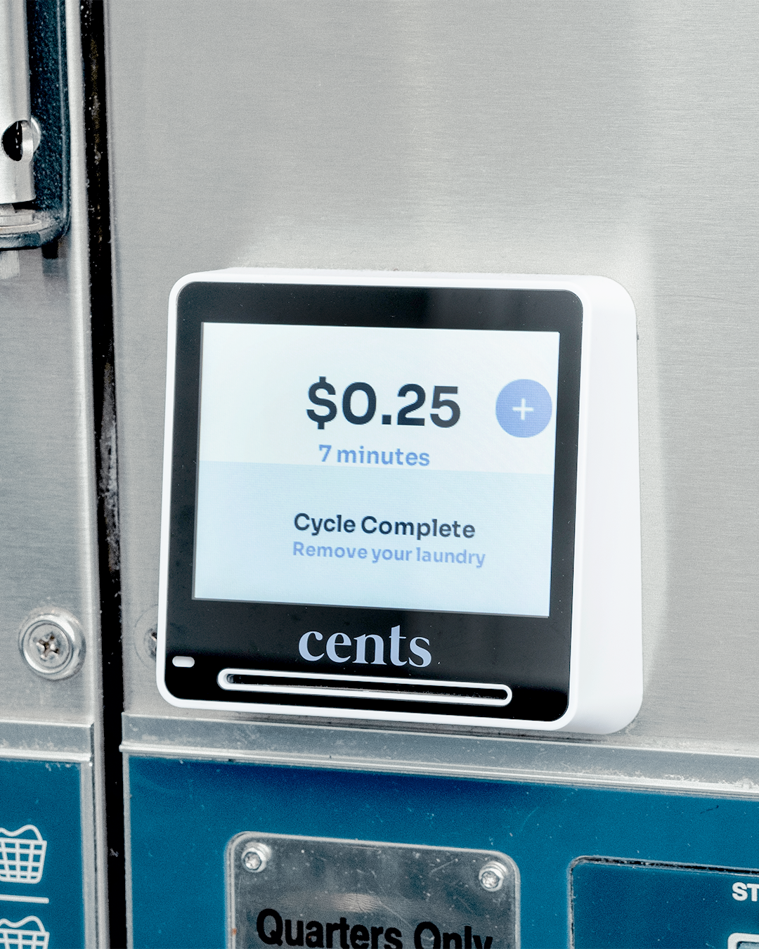 A digital payment panel on a laundry machine showing a charge of 25 cents for 7 minutes of laundry, with options to add more time and a message saying cycle complete.
